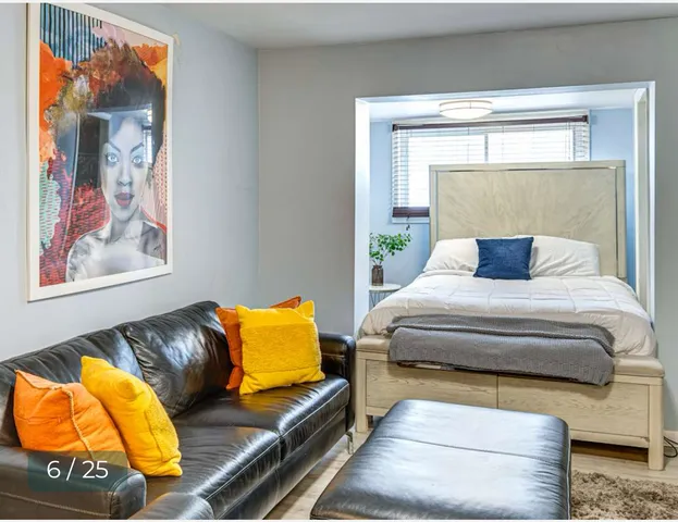 a living room with stainless steel appliances furniture a rug and a couch