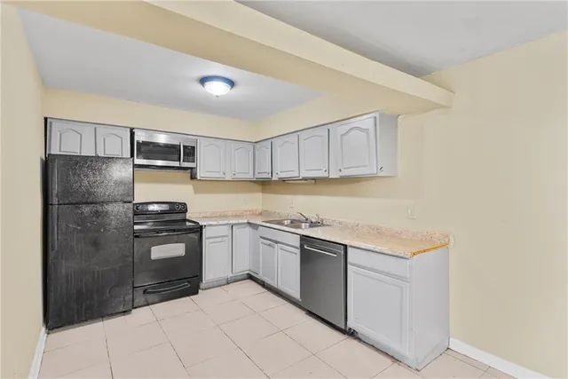 a kitchen with stainless steel appliances granite countertop a refrigerator sink and stove