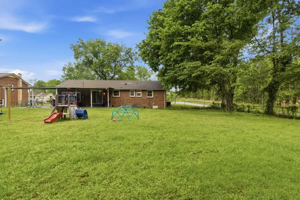 a view of a house with backyard and a patio