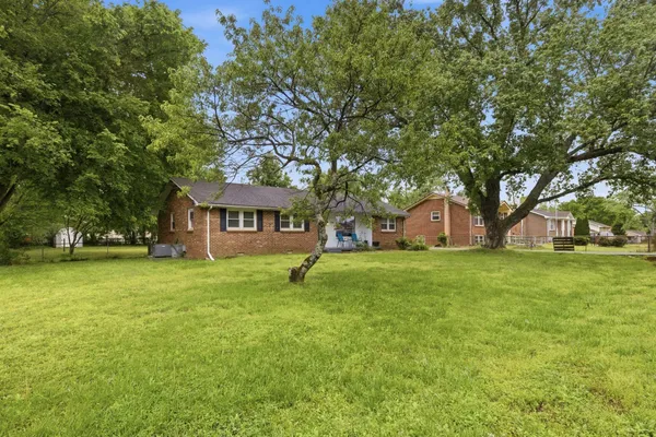 a front view of a house with a garden and trees