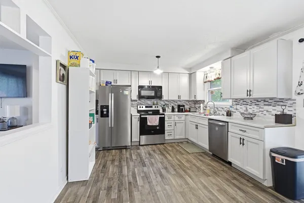 a kitchen with granite countertop a refrigerator stove and oven