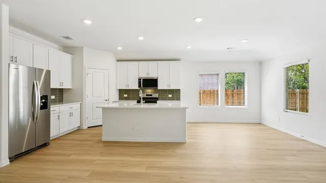 a kitchen with stainless steel appliances a refrigerator sink and microwave