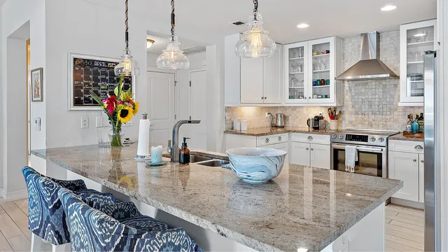 a kitchen with stainless steel appliances granite countertop a sink a stove and a wooden cabinets