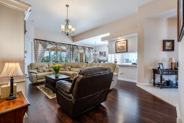a living room with furniture a dining table and a chandelier