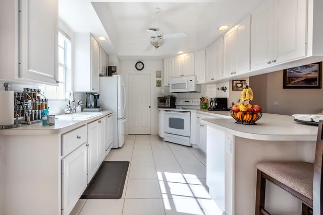 a kitchen with white cabinets and white appliances