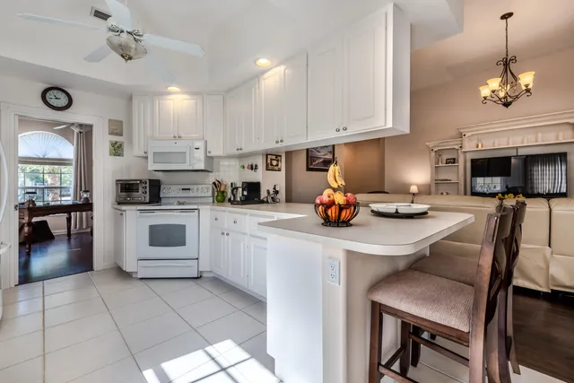 a kitchen with stainless steel appliances a stove a sink a oven a dining table and chairs