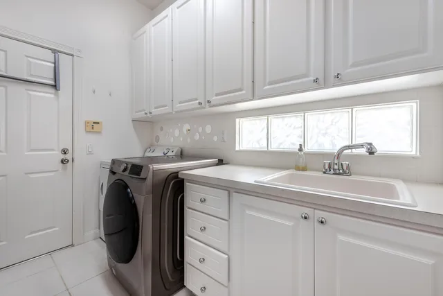 a utility room with cabinets washer and dryer