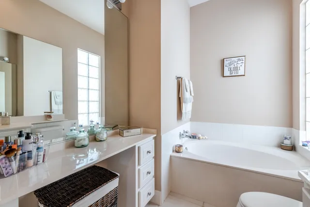 a bathroom with a tub sink and mirror