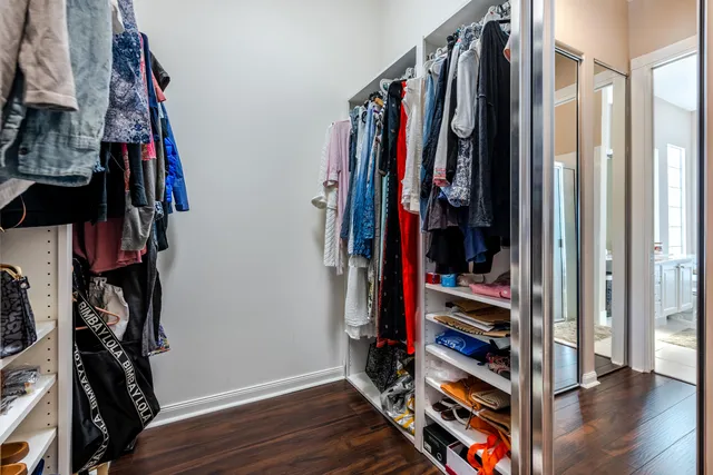 a view of walk in closet with clothes and shoes