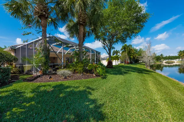 a view of a house with a yard and palm trees