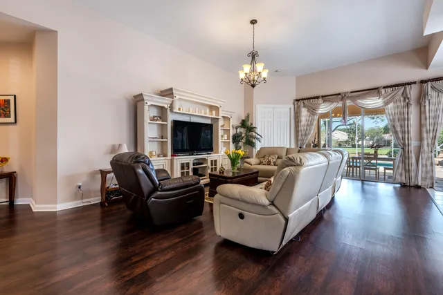 a living room with furniture a fireplace and a chandelier