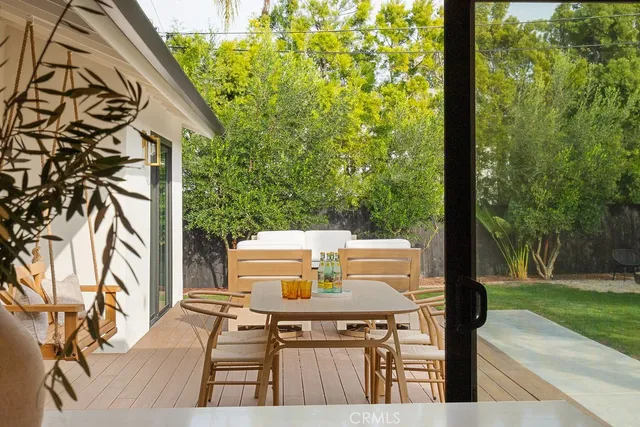 a view of a patio with table and chairs with wooden floor and fence