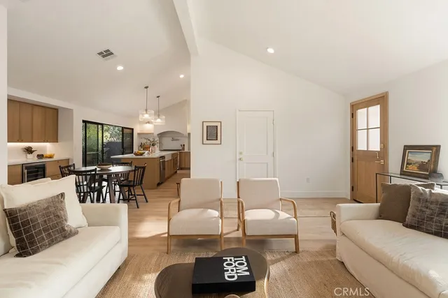 a living room with furniture and a view of kitchen