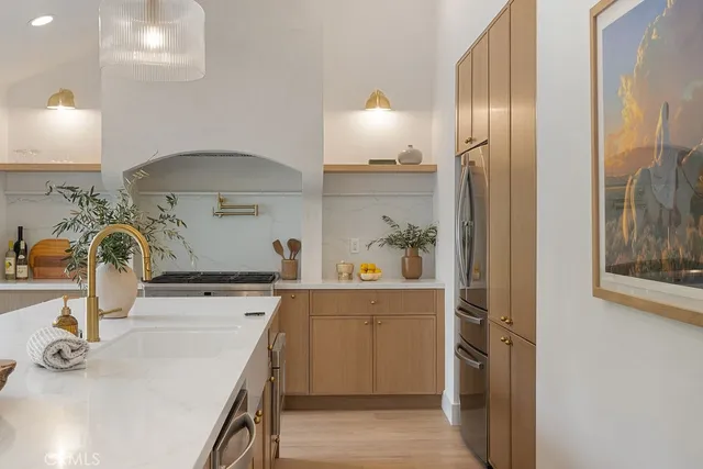 a kitchen with stainless steel appliances a sink a stove and a refrigerator