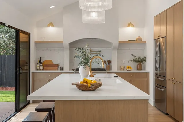 a kitchen with stainless steel appliances granite countertop a refrigerator a stove and a sink with wooden floor