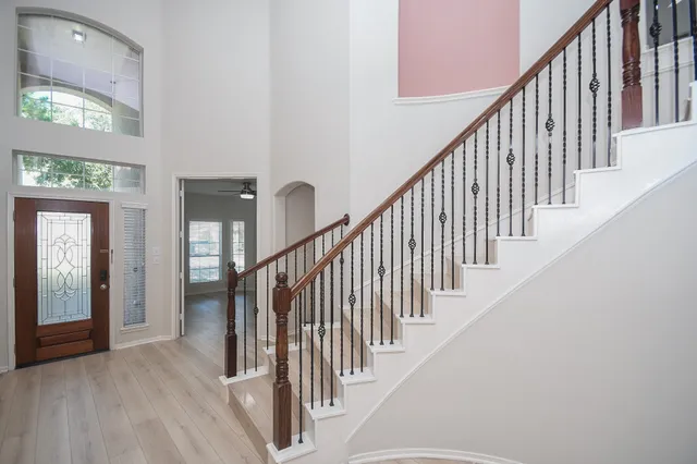 a view of staircase with lots of frames on wall and windows