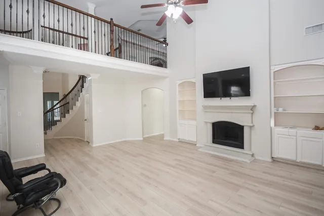 a view of an empty room with a fireplace and a window