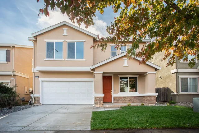 a front view of a house with a yard and garage