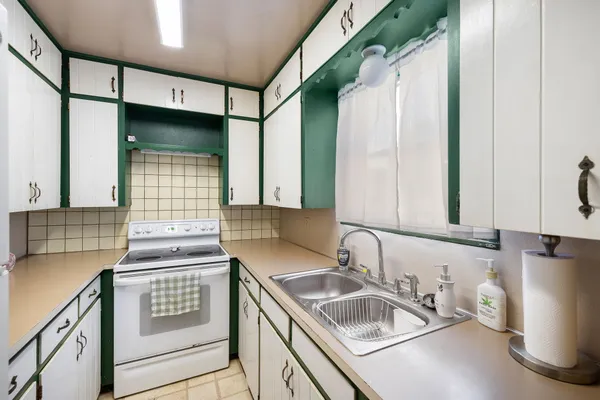a kitchen with a sink cabinets and a window