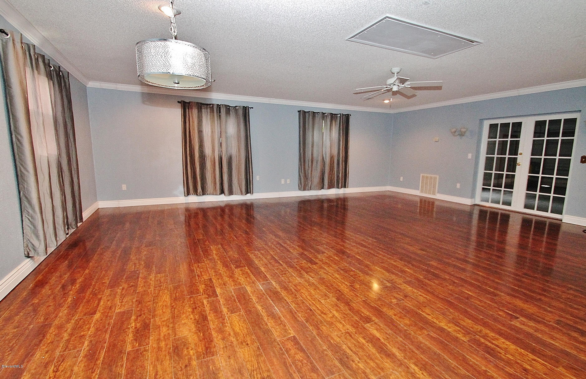 238 Capron Road Port St. John, FL 32927 - Photo 17 of 23 an empty room with wooden floor and chandelier