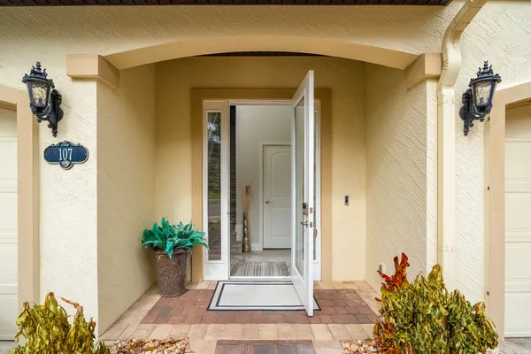 a view of a house with a yard and potted plants