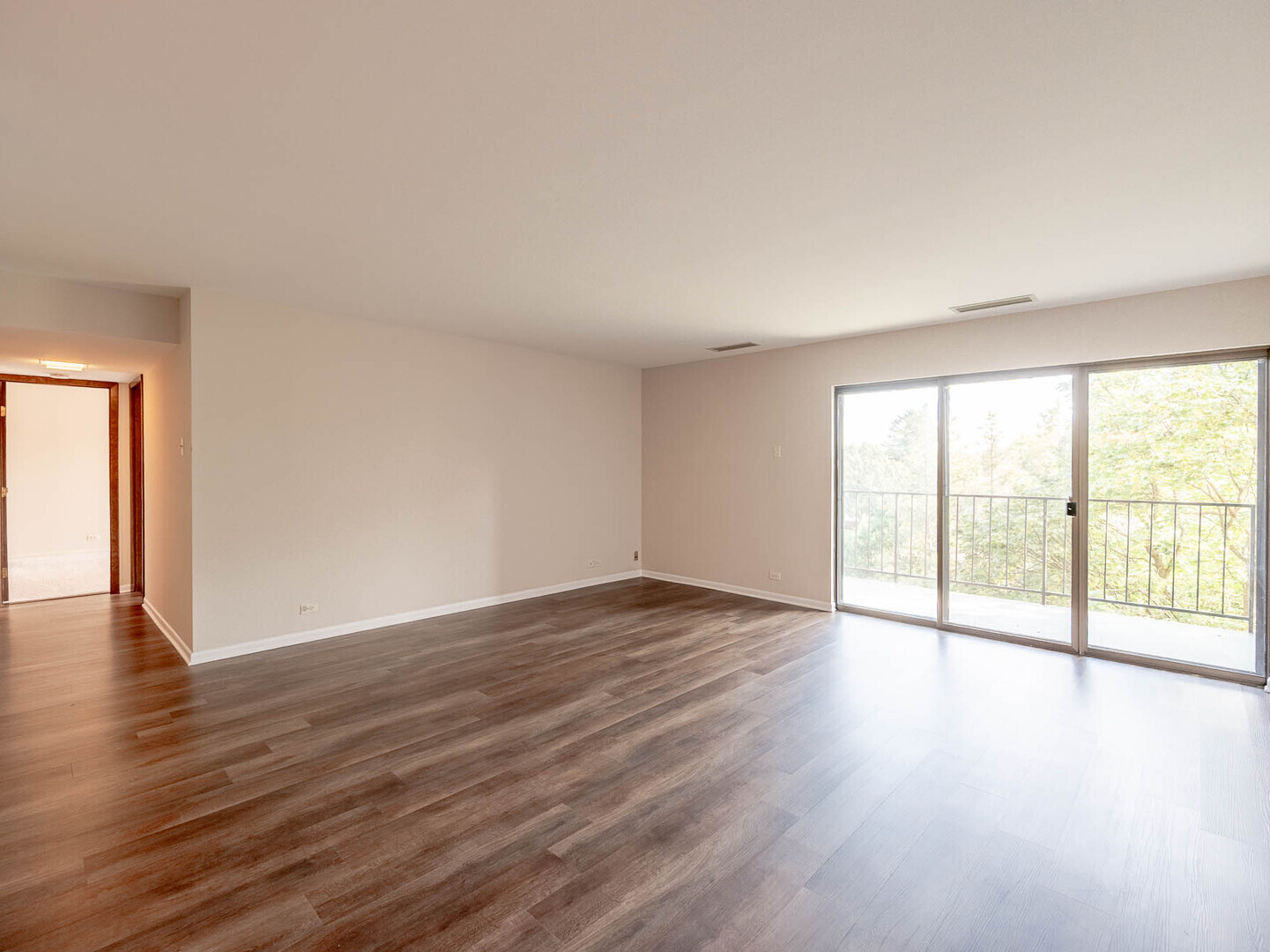 6545 Main Street, Unit 408 Downers Grove, IL 60516 - Photo 3 of 13 a view of an empty room with wooden floor and a window