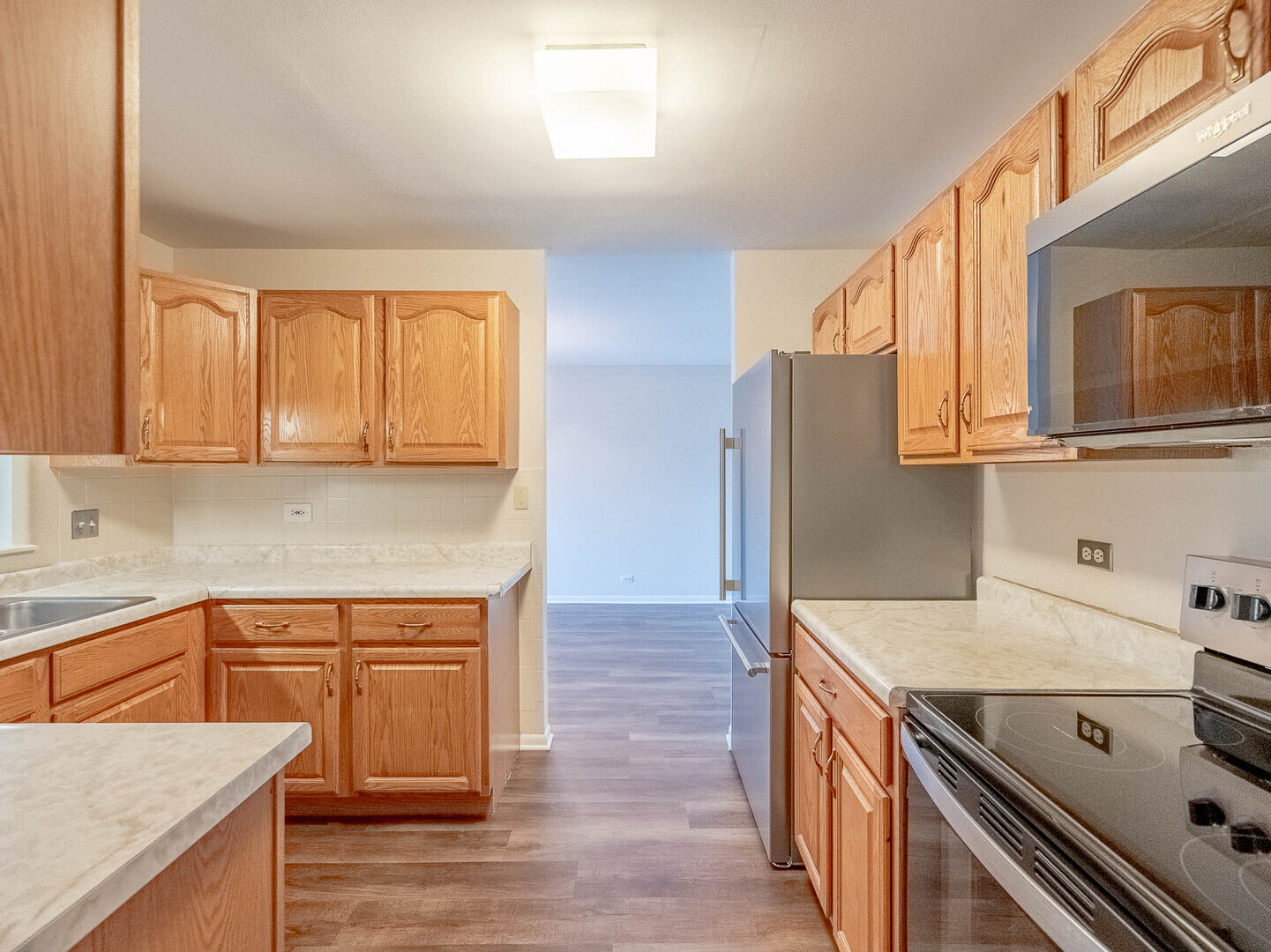 6545 Main Street, Unit 408 Downers Grove, IL 60516 - Photo 5 of 13 a kitchen with stainless steel appliances granite countertop a sink a stove and a refrigerator