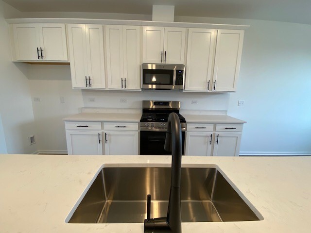 4515 Chelsea Mnr Circle, Unit 4515 Aurora, IL 60504 - Photo 12 of 37 a kitchen with a sink cabinets and stainless steel appliances