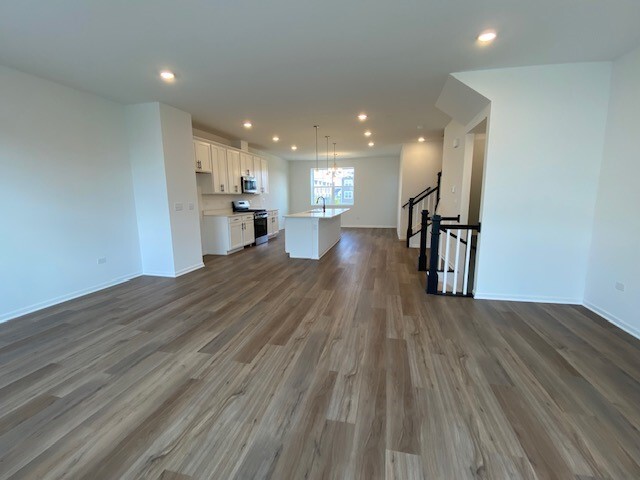 4515 Chelsea Mnr Circle, Unit 4515 Aurora, IL 60504 - Photo 6 of 37 a view of a big room with wooden floor and a kitchen