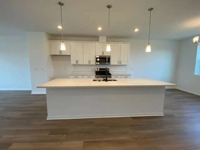 a view of kitchen with stainless steel appliances granite countertop a sink a stove and a wooden floor