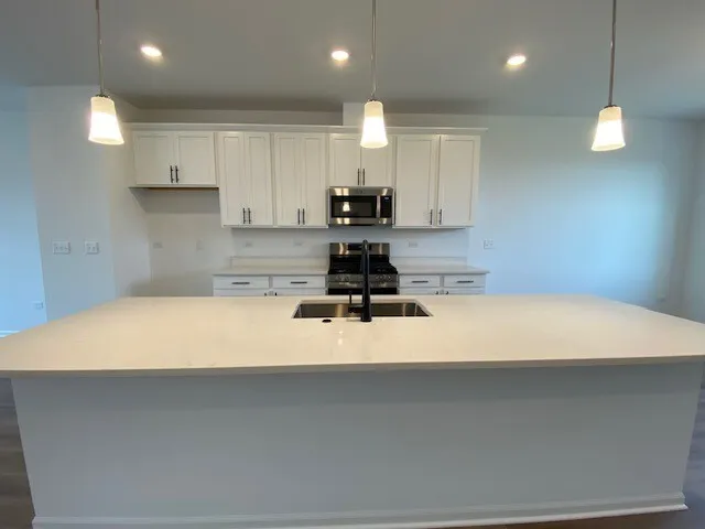 a kitchen with kitchen island a stove a counter top space and a center island