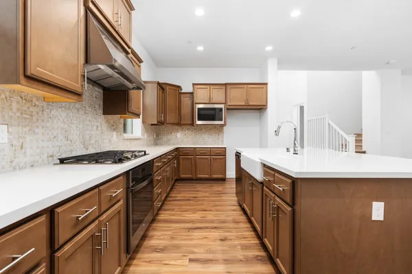 a kitchen with stainless steel appliances a sink stove and cabinets