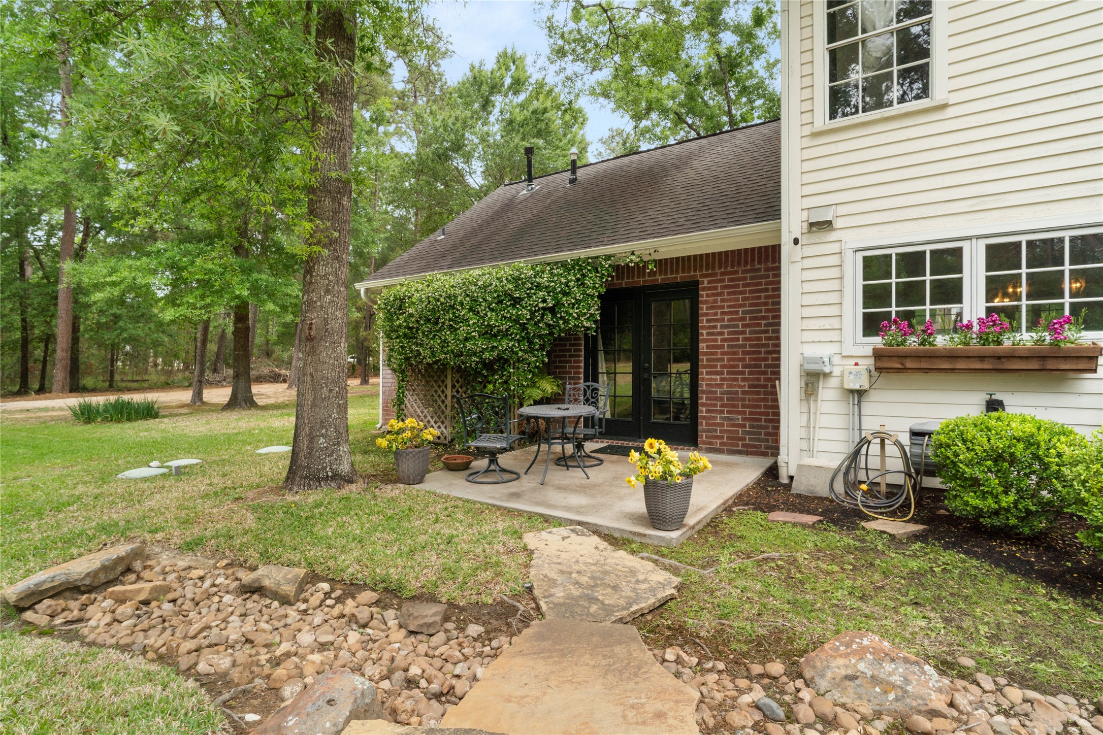 36 Wind River Drive Conroe, TX 77384 - Photo 14 of 45 A very peaceful patio just outside the doors of the downstairs primary bedroom. Perfect for coffee in the morning or just enjoying the view anytime of the day.