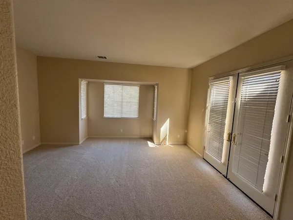 a view of an empty room with window and closet area