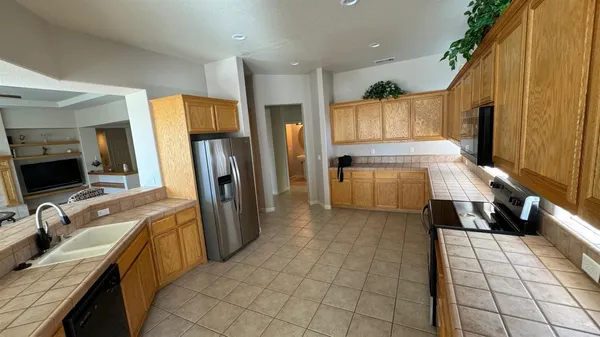a kitchen with a sink a counter top space appliances and cabinets