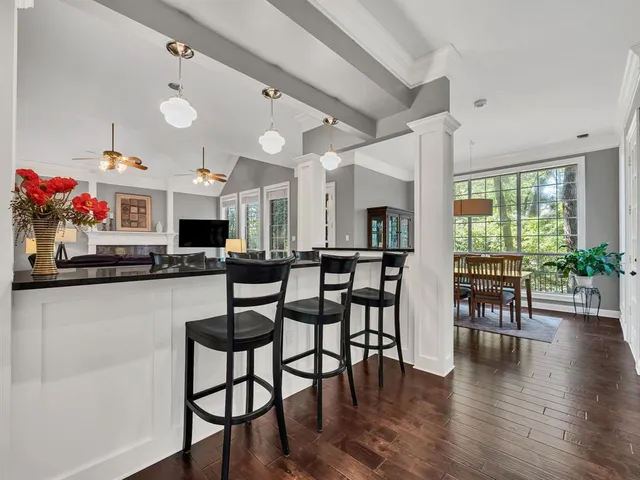 a kitchen with stainless steel appliances granite countertop dining table chairs and wooden floor