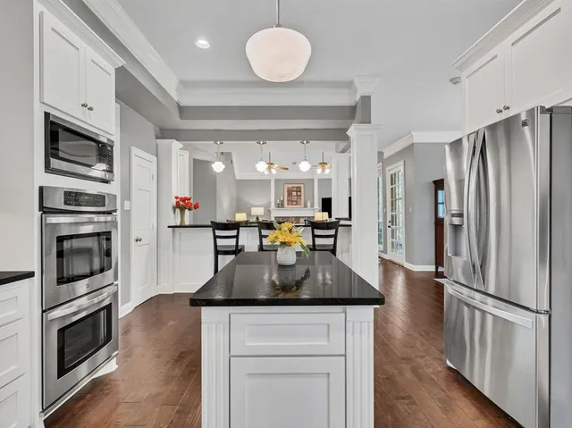 a kitchen with stainless steel appliances granite countertop a refrigerator a stove microwave and a sink