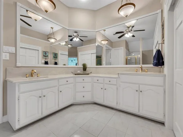 a spacious bathroom with a double vanity sink mirror and bathtub