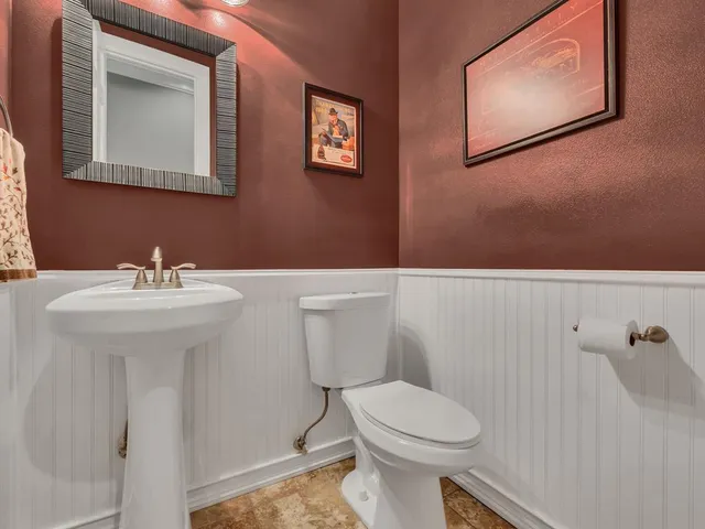 a bathroom with a sink mirror and toilet