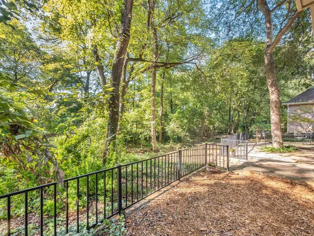 a view of a yard with wooden fence