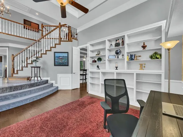 a livingroom with furniture staircase and a ceiling fan