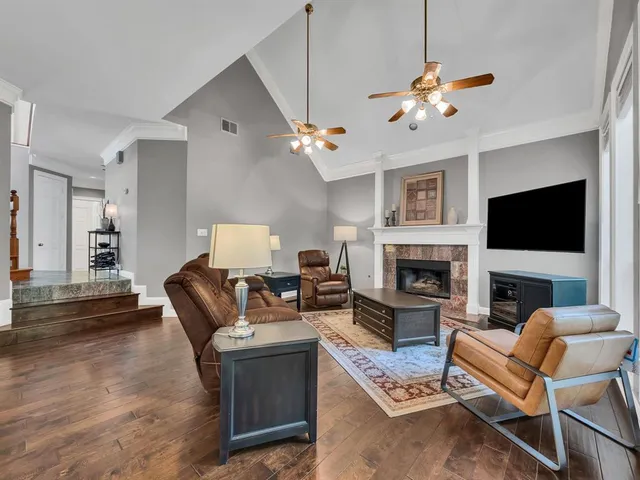 a living room with furniture a fireplace and a flat screen tv