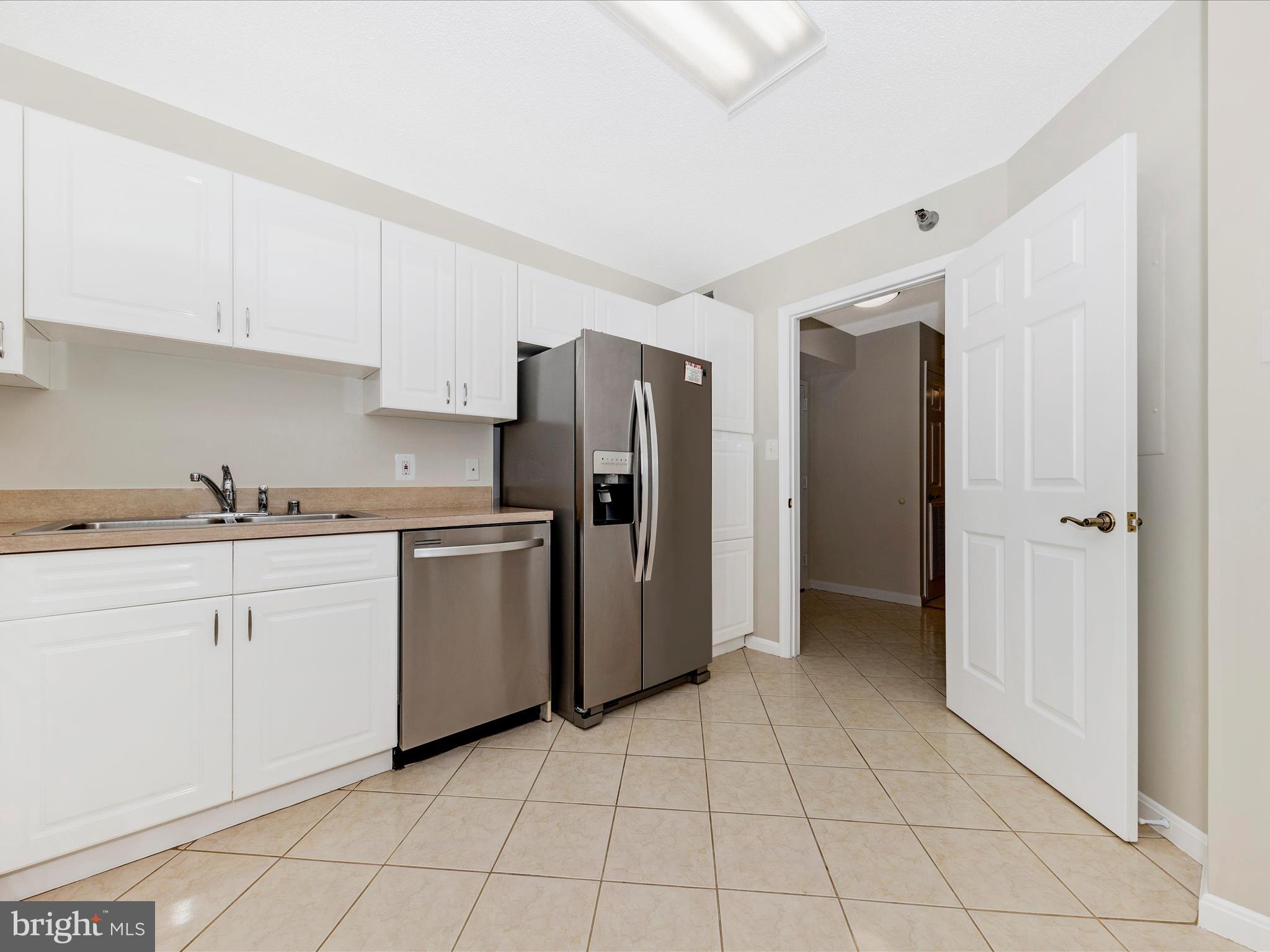 14809 Pennfield Circle, Unit 402 Silver Spring, MD 20906 - Photo 11 of 59 a kitchen with a refrigerator sink and cabinets