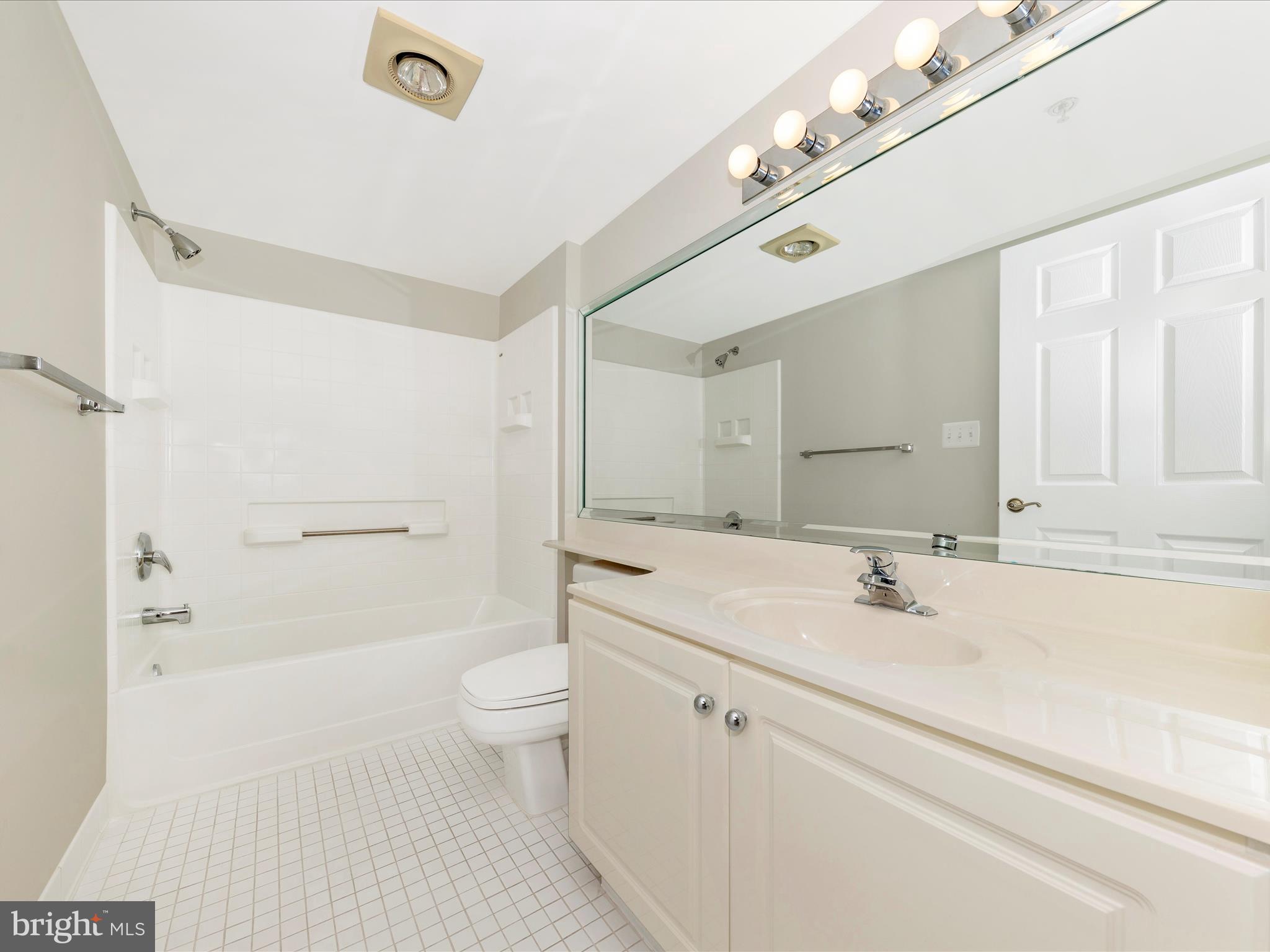 14809 Pennfield Circle, Unit 402 Silver Spring, MD 20906 - Photo 19 of 59 a bathroom with a sink a toilet a shower and a mirror