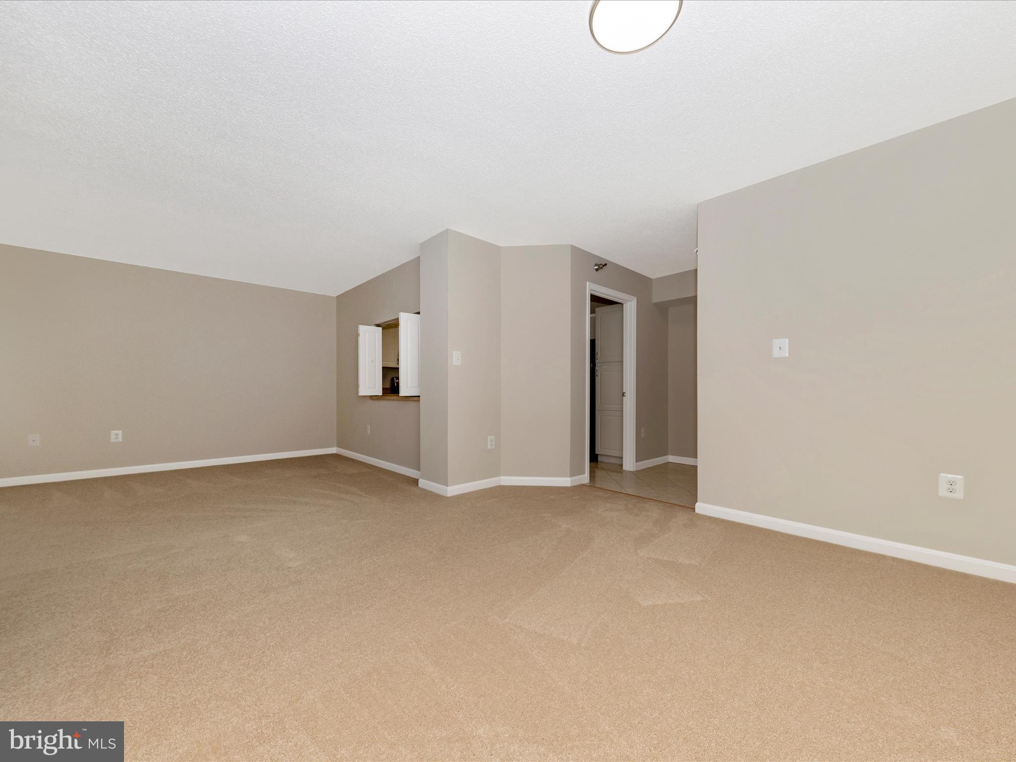 14809 Pennfield Circle, Unit 402 Silver Spring, MD 20906 - Photo 8 of 59 a view of an empty room with wooden floor and window