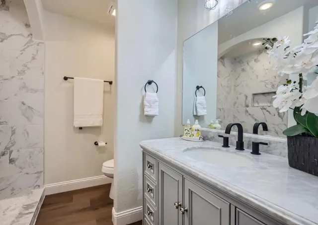 a bathroom with a sink a toilet and shower