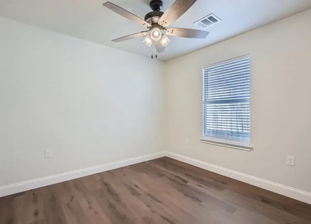 wooden floor in an empty room with a window