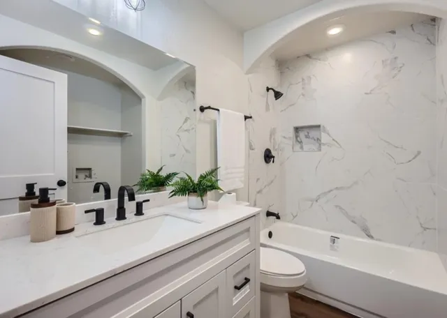 a bathroom with a sink a toilet and shower