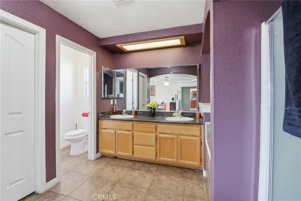a spacious bathroom with a granite countertop sink a mirror and a bathtub