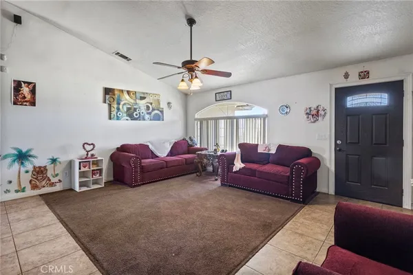 a living room with furniture a chandelier and a large window